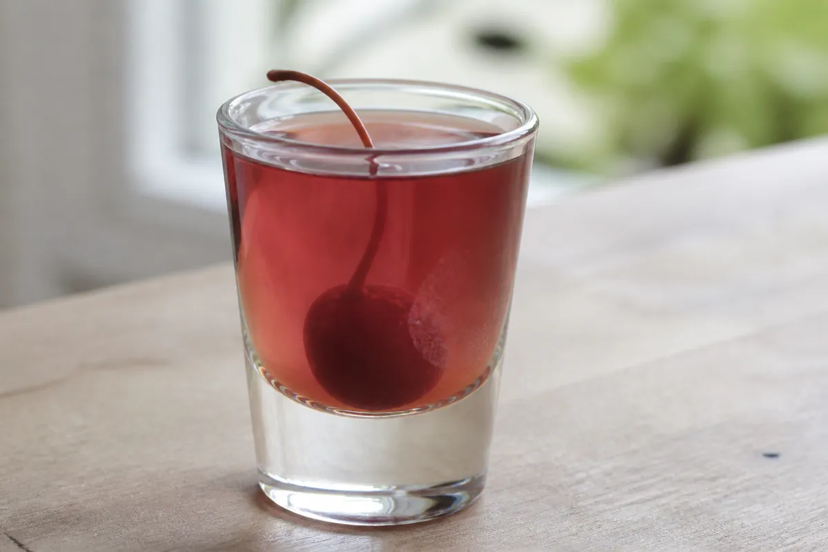 A Royal Flush shot in a glass with a deep red hue.