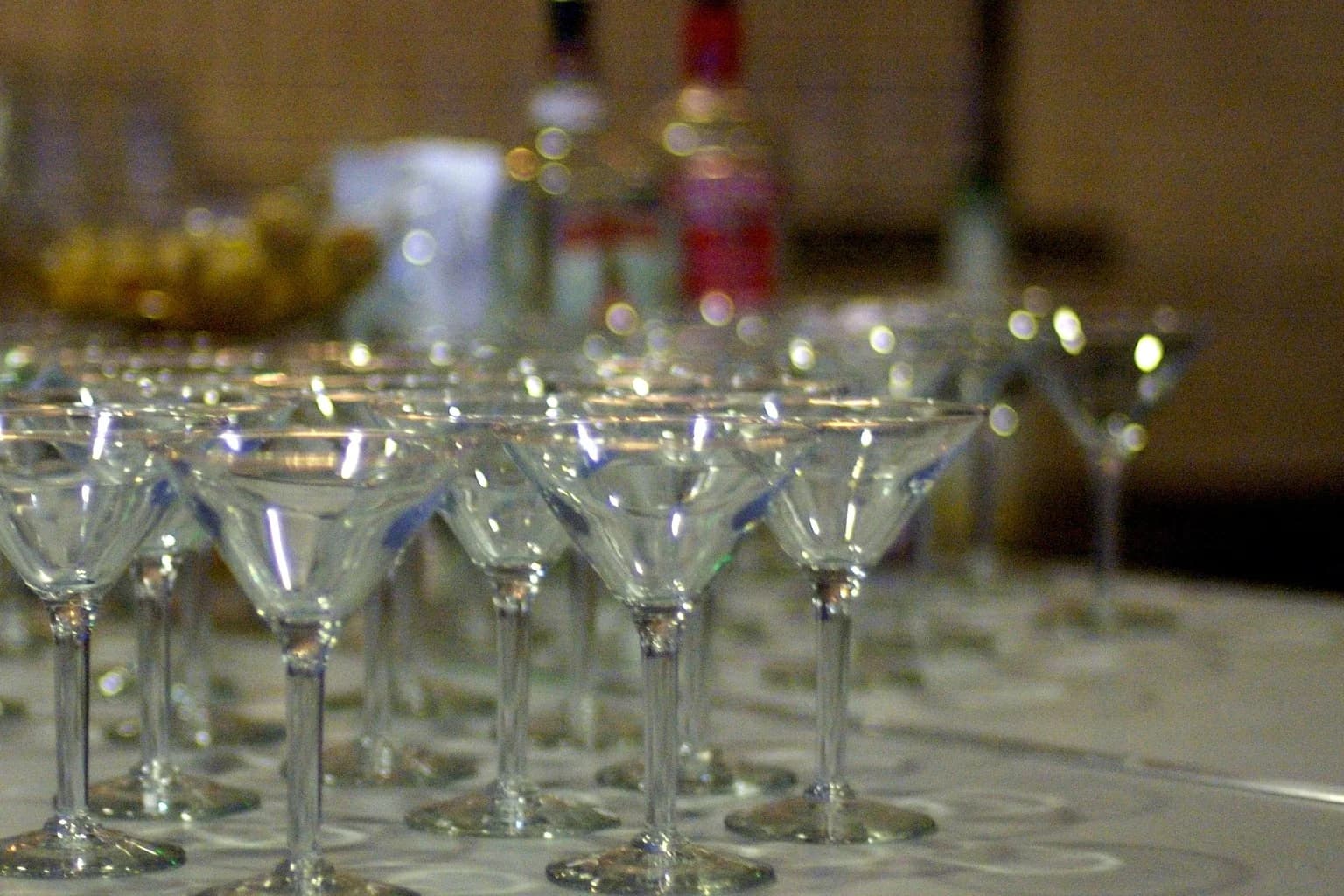 Rows of chilled cocktail glasses ready for service on a bar