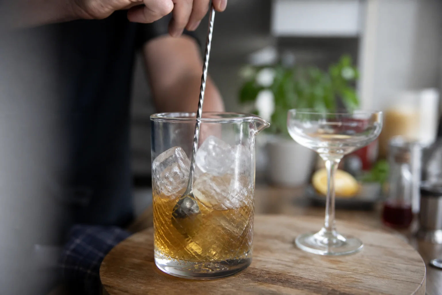 Barspoon stirring a clear cocktail in a mixing glass