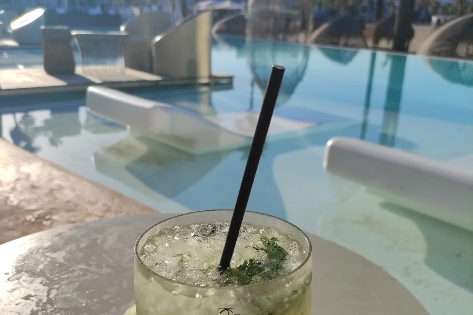 A Mojito packed with crushed ice and mint, photographed poolside