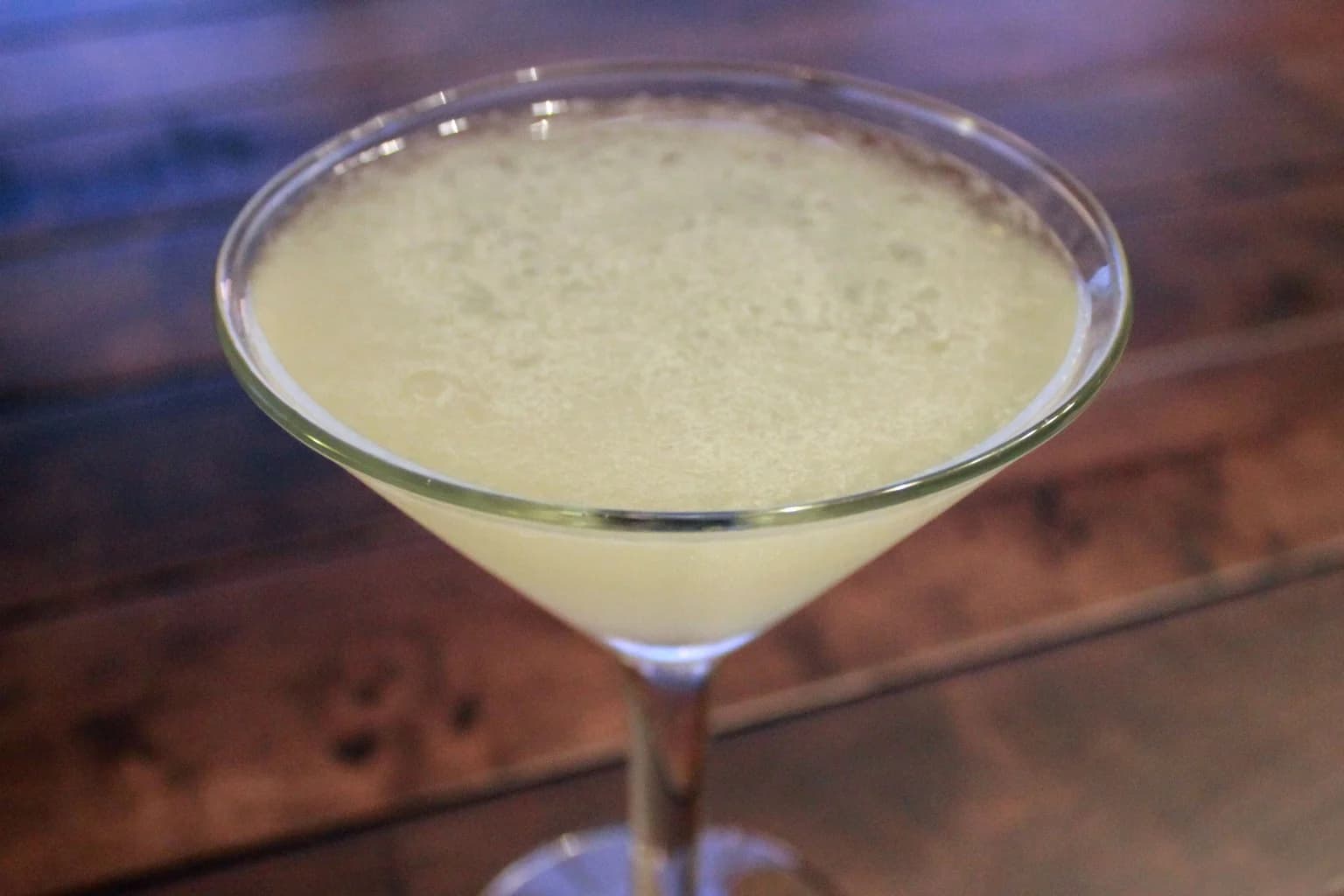 A classic Daiquiri in a stemmed cocktail glass on dark wood