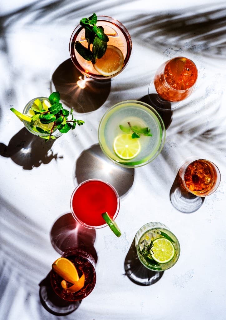 A Mai Tai in a double old-fashioned glass packed with crushed ice, mint bouquet, and lime shell on a tropical bar.