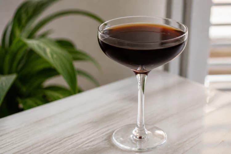 Black Magic in a coupe, deep brown-black, ungarnished.