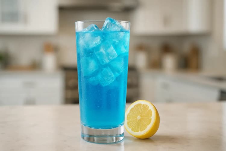 A tall Blue Lagoon with bright blue color and a lemon wheel.
