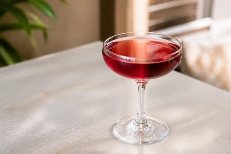 Cranberry Cosmo in a coupe, deep pink-red, ungarnished.