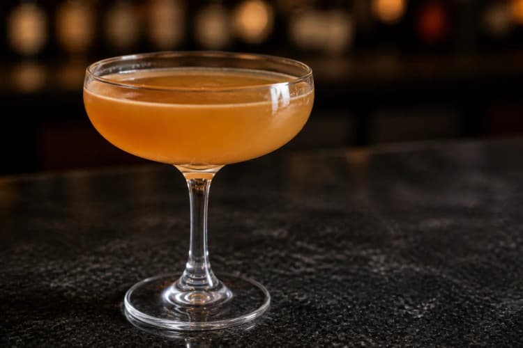 Paradise served in a chilled coupe, soft orange-gold in color, no garnish required.