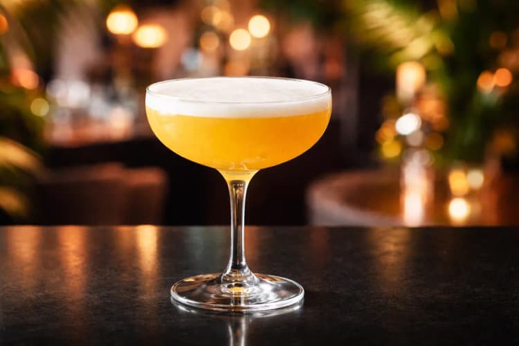 A Pornstar Martini with passionfruit half floating on the foam.