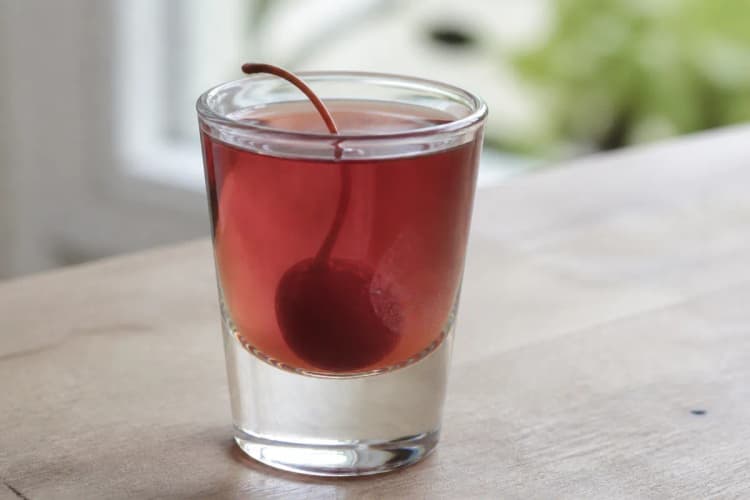 A Royal Flush shot in a glass with a deep red hue.