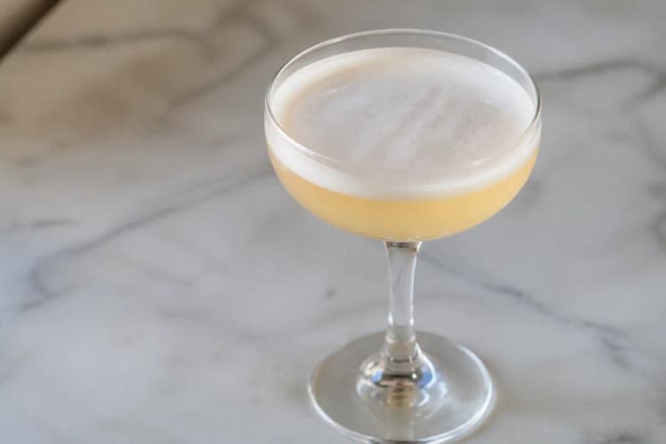 Trade Winds in a coupe, pale gold with soft foam, ungarnished.