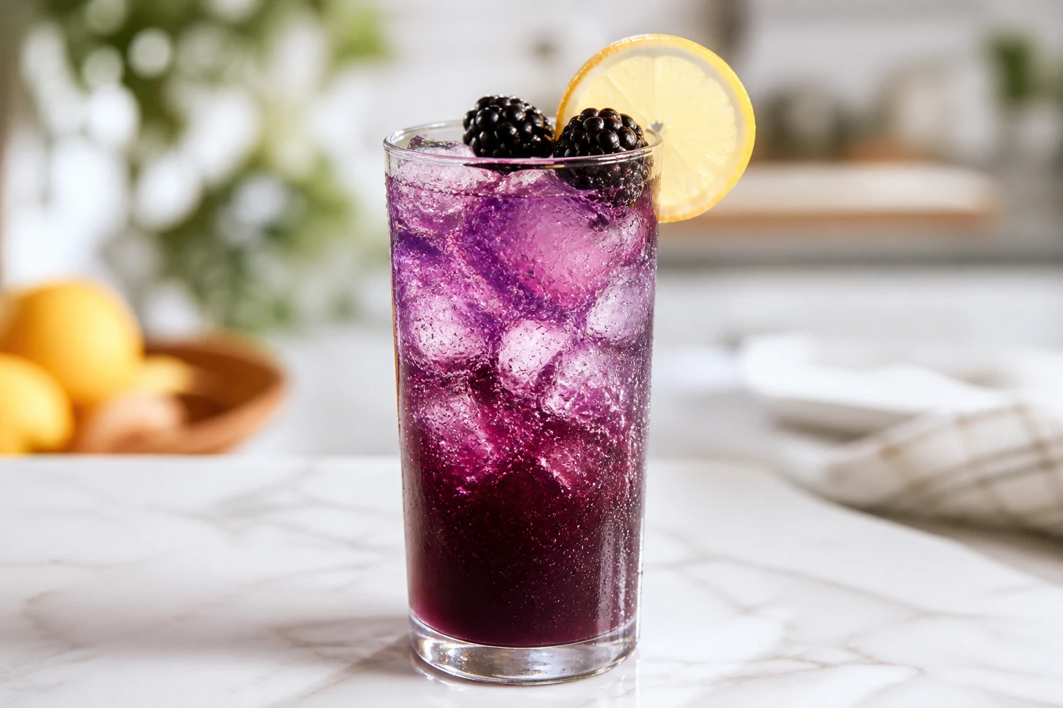 Witches' Brew Mocktail in a highball over ice, deep purple grape ginger-ale soda with lemon and blackberries.