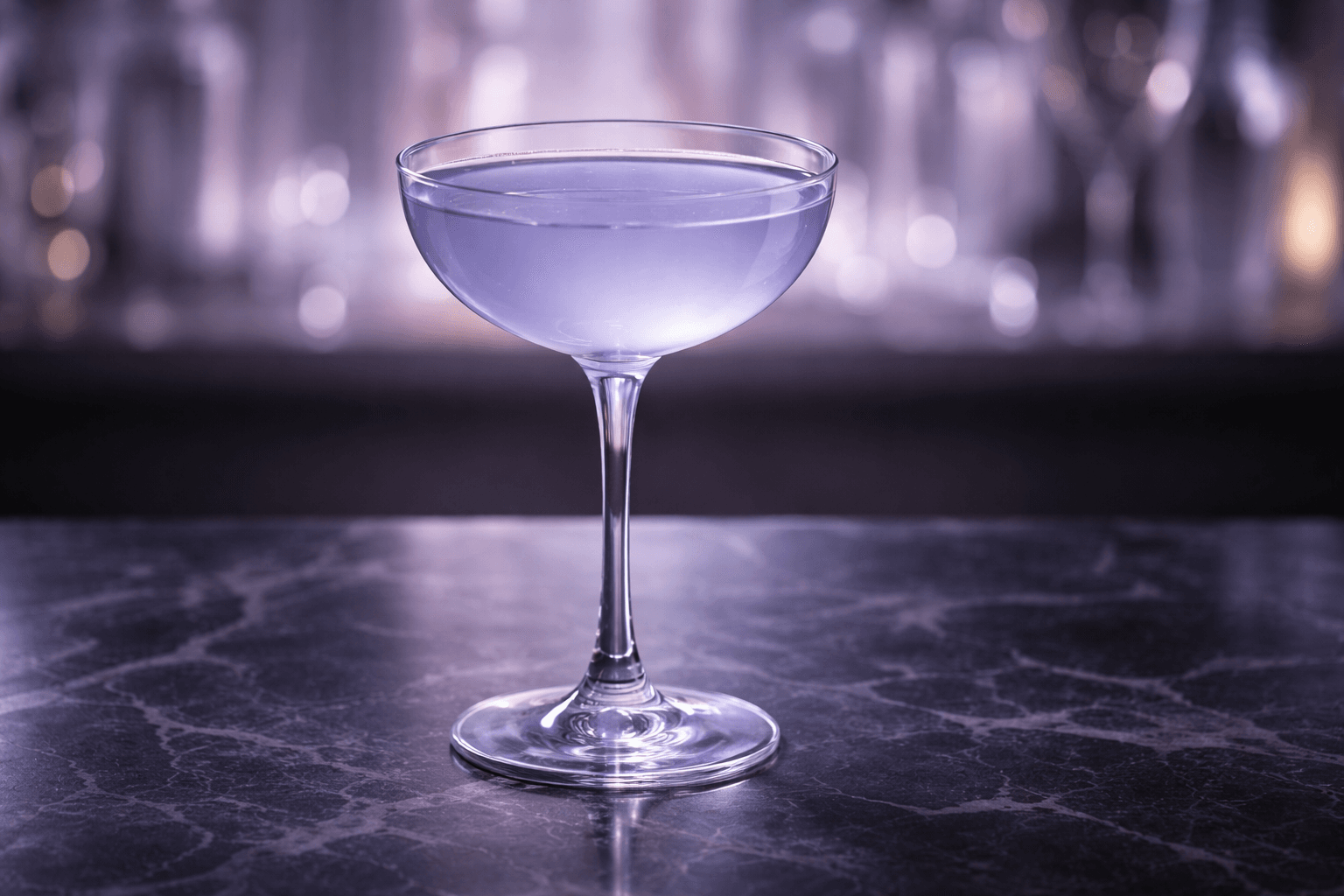 A Blue Moon Cocktail with a faint lavender tint served in a coupe.