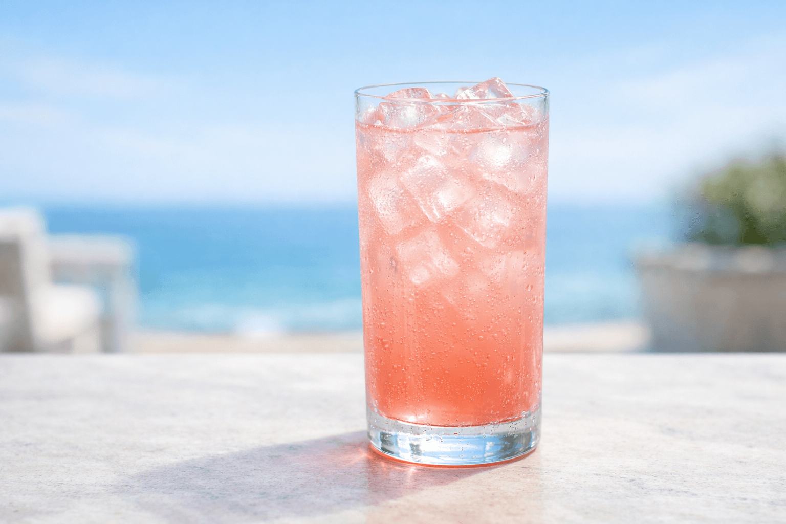 A tall Sea Breeze over ice with ruby-pink color and lime wedge.