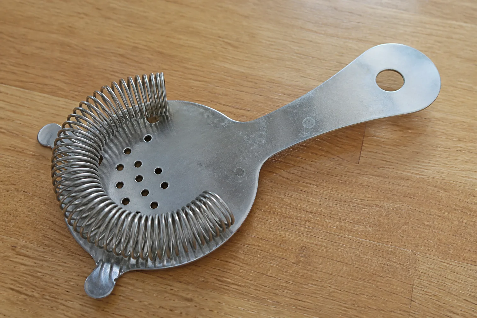 Hawthorne cocktail strainer on a kitchen counter