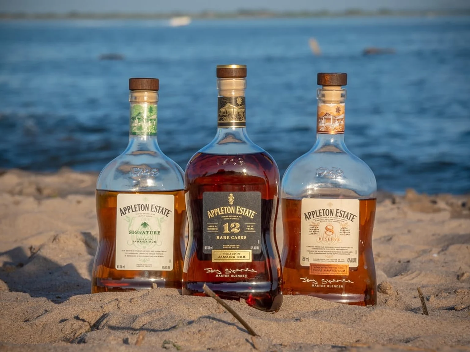 Three Appleton Estate aged rums in the sand, gold to mahogany