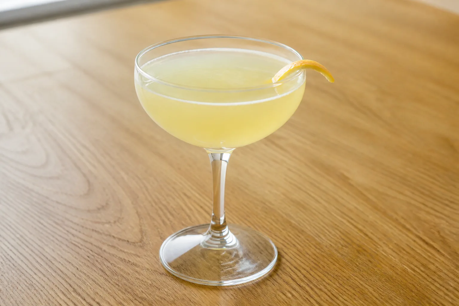 A citrus sour cocktail in a coupe glass