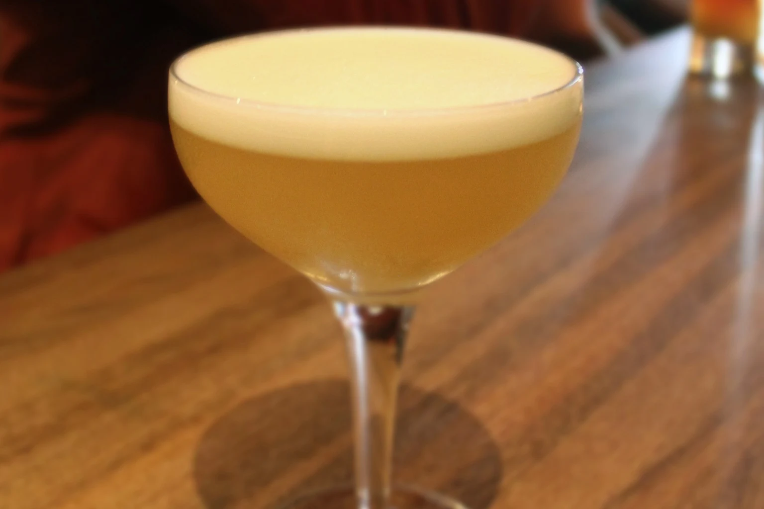 A Whiskey Sour served up in a coupe with an egg-white foam head