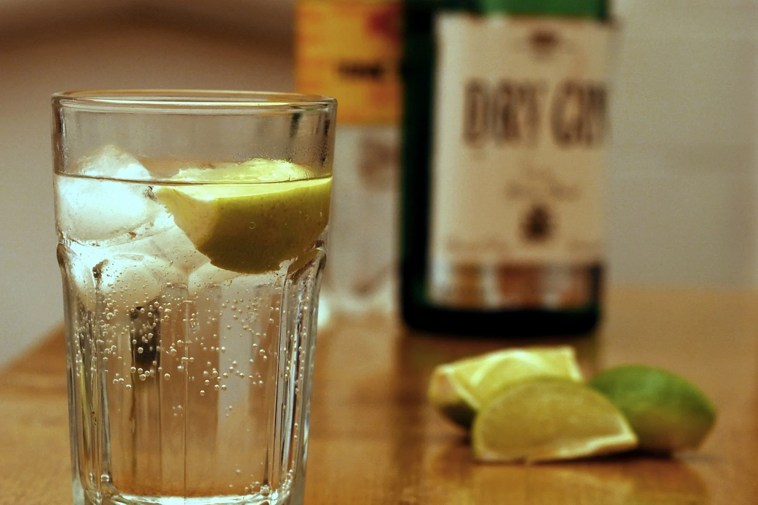 A gin and tonic in a highball with packed ice and lime